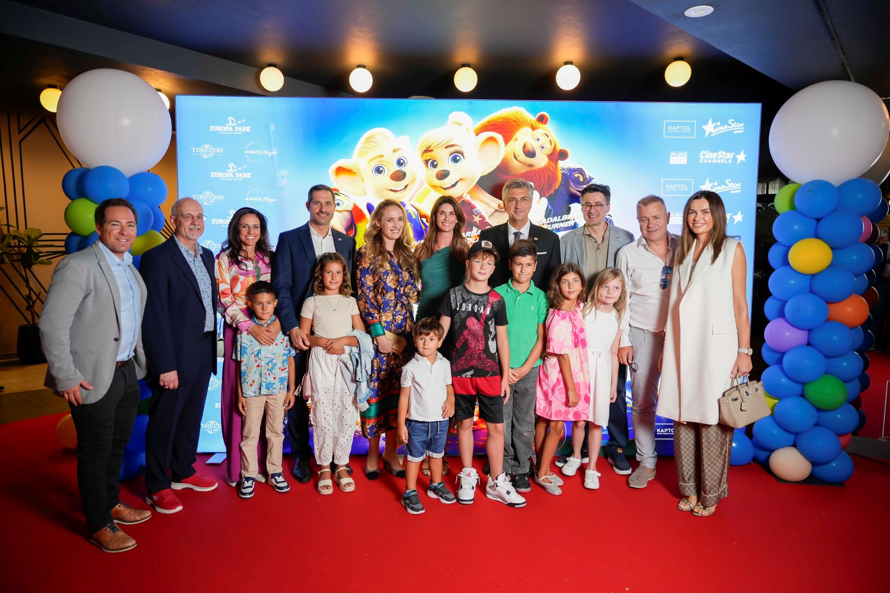 Večer je bila posvećena slavlju mašte, zabave i emocije – ujedno i obilježavanju 50 godina postojanja Europa-Parka, najvećeg i najnagrađivanijeg zabavnog parka na svijetu. Obitelj Mack, koja stoji iza ovog europskog kraljevstva zabave, stigla je u Zagreb i time događaju dala poseban međunarodni pečat. Inspiracija za sam film upravo je i proizašla iz jedinstvenog duha Europa-Parka, mjesta koje godišnje posjeti više od šest milijuna ljudi. Kaptol Boutique Cinema za tu je priliku pretvoren u glamuroznu pozornicu – centralni prostor ukrašavala je stilizirana trkaća staza, dok su kostimirani junaci i tematske animacije unijeli dodatnu dozu bajkovite atmosfere. Najmlađi gosti uživali su u druženju s likovima iz filma, dok su odrasli bili očarani atraktivnim vizualima i energijom cijele večeri. Premijera je okupila i niz uvaženih uzvanika – među kojima su bili predsjednik Vlade Andrej Plenković s obitelji, počasna konzulica Miriam Mack, ministar turizma i sporta Tonči Glavina, brojni strani producenti i filmski djelatnici, ali i domaća kulturna i društvena scena. Na crvenom tepihu pojavili su se poznata lica poput Monike Mihajlović, Ane Radišić, Petra Kurtele, Lucije Lugomer i mnogih drugih. „Velika utrka Europe” publici donosi priču o junacima Edu i Eddi u dirljivoj avanturi punoj akcije, smijeha i emocija, a hrvatsku sinkronizaciju potpisuju neka od najpoznatijih domaćih imena – od Monike Mihajlović i Ivana Glowatzkog, do Jasne Palić Picukarić, Barbare Nole i Frane Ridjana. Poseban detalj za domaću publiku jest i poveznica filma s Hrvatskom – impresivni rollercoaster Voltron – Nevera, nastao u suradnji s tvrtkom Rimac, dodatno povezuje našu zemlju s ovim europskim simbolom zabave. Glazbu za film potpisuje njemački oskarovac Volker Bertelmann, a producent je Michael Mack, dok je CineStar Channels pružio podršku premijeri kao službeni medijski pokrovitelj. Večer u Kaptol Boutique Cinemu još jednom je pokazala da film nije samo projekcija na platnu – već iskustvo koje okuplja, inspirira i budi dijete u svakome od nas. „Velika utrka Europe” to je sinoć potvrdila na najbolji mogući način – pretvorivši Zagreb u grad filmske čarolije.